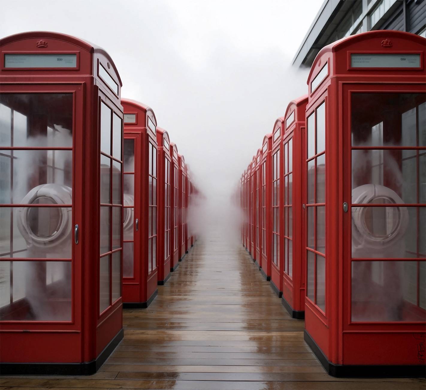 Cabines rouges en enfilade dans une ruelle sombre ou brumeuse. Red phone boxes lined up in a dark or foggy alley.